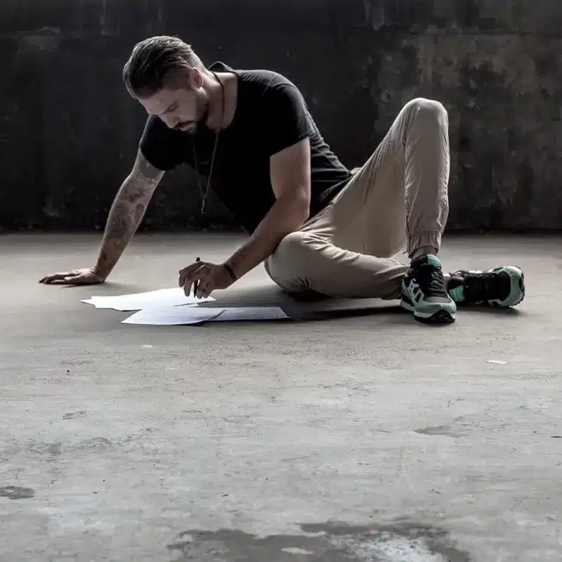 Man sitting on the ground with a piece of paper