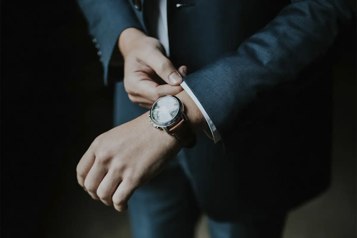 Man holding a watch on his hands