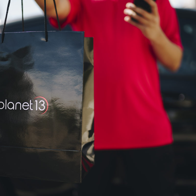 man holding Planet 13 bag