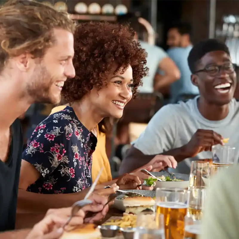 Two young boys and a young woman enjoying a meal at a restaurant