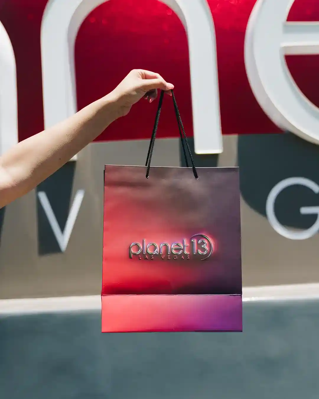 Hand holding a Planet 13 bag