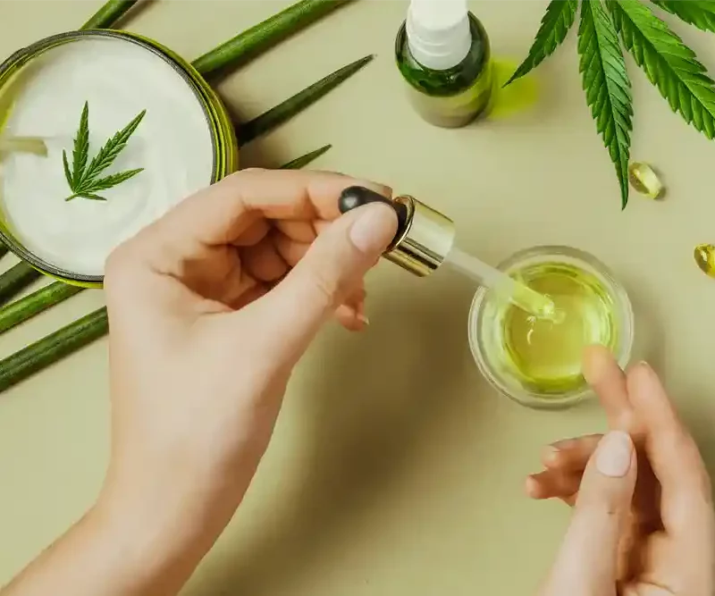 Close up of a hand handling cannabis tinctures