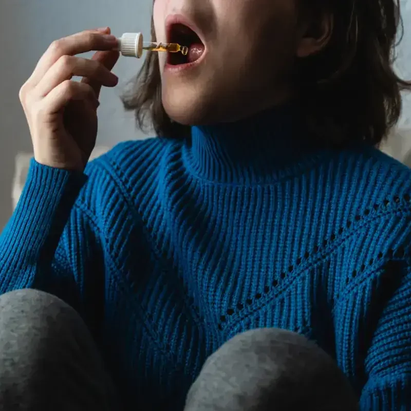 woman taking cannabis drops