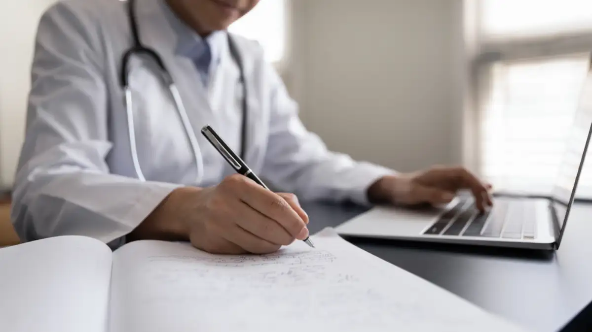 Close up of woman doctor in white uniform with stethoscope taking notes