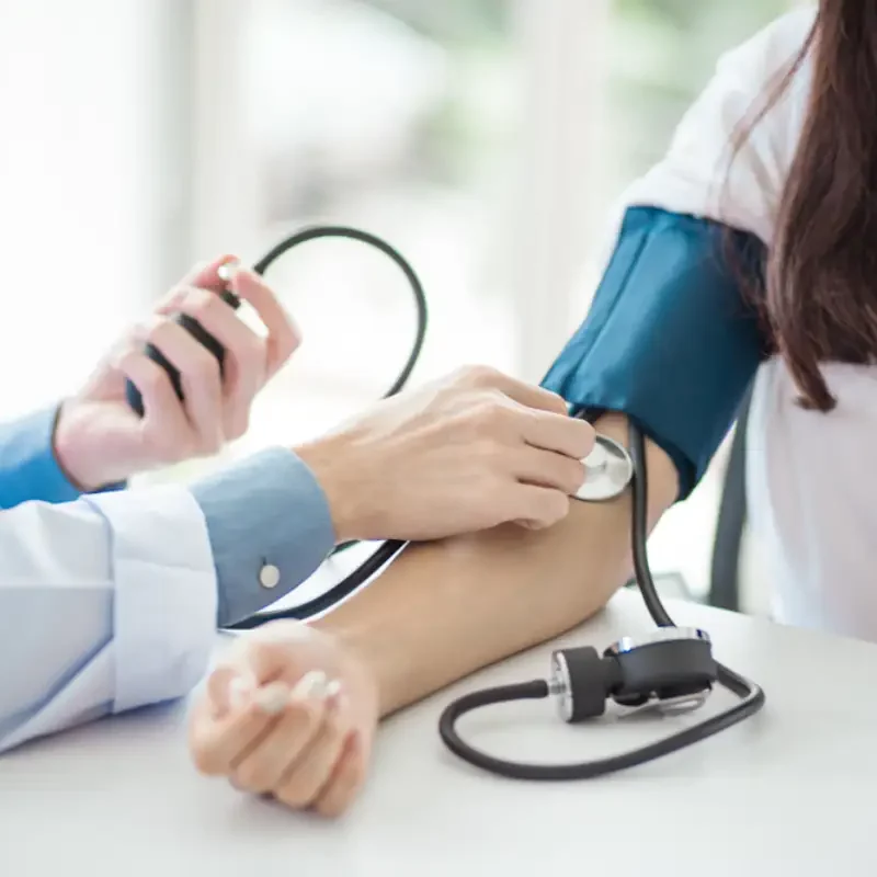 Doctor using sphygmomanometer with stethoscope checking blood pressure to a patient in the hospital