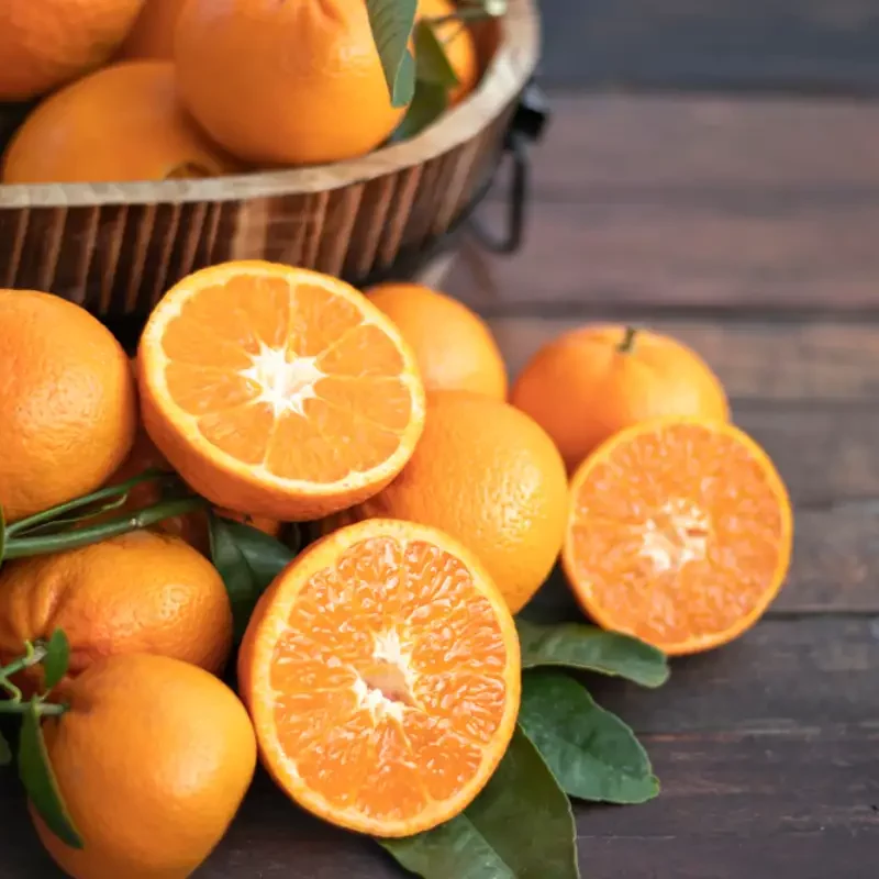 Orange fruit with green leaves on the table