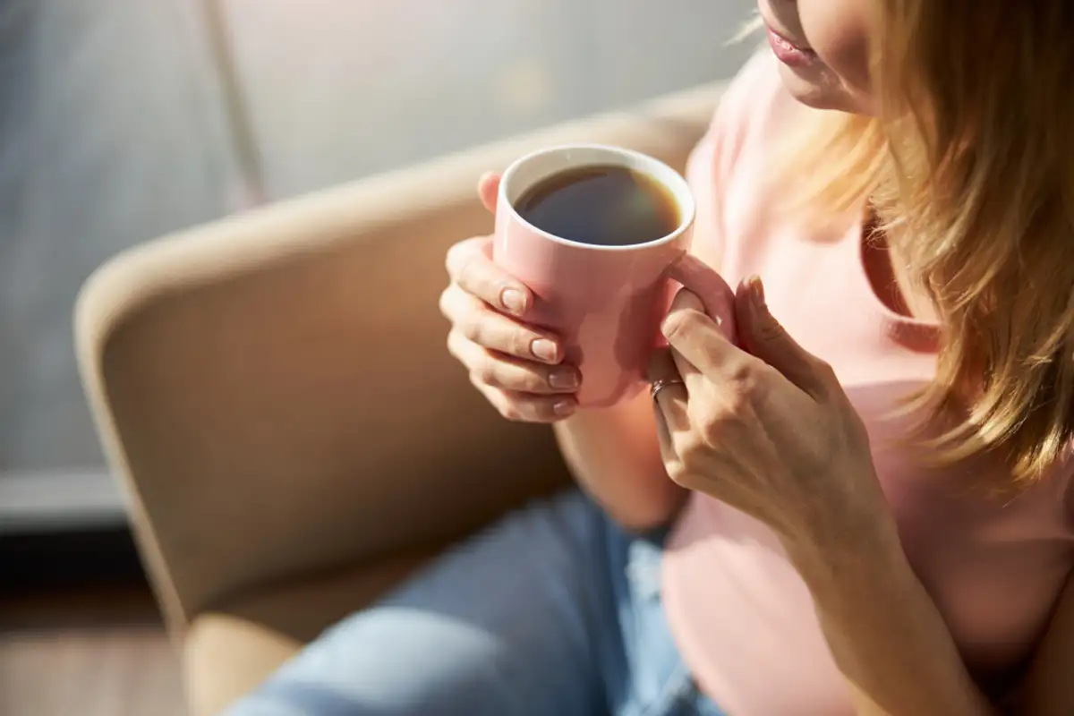 Woman drinking coffee on couch