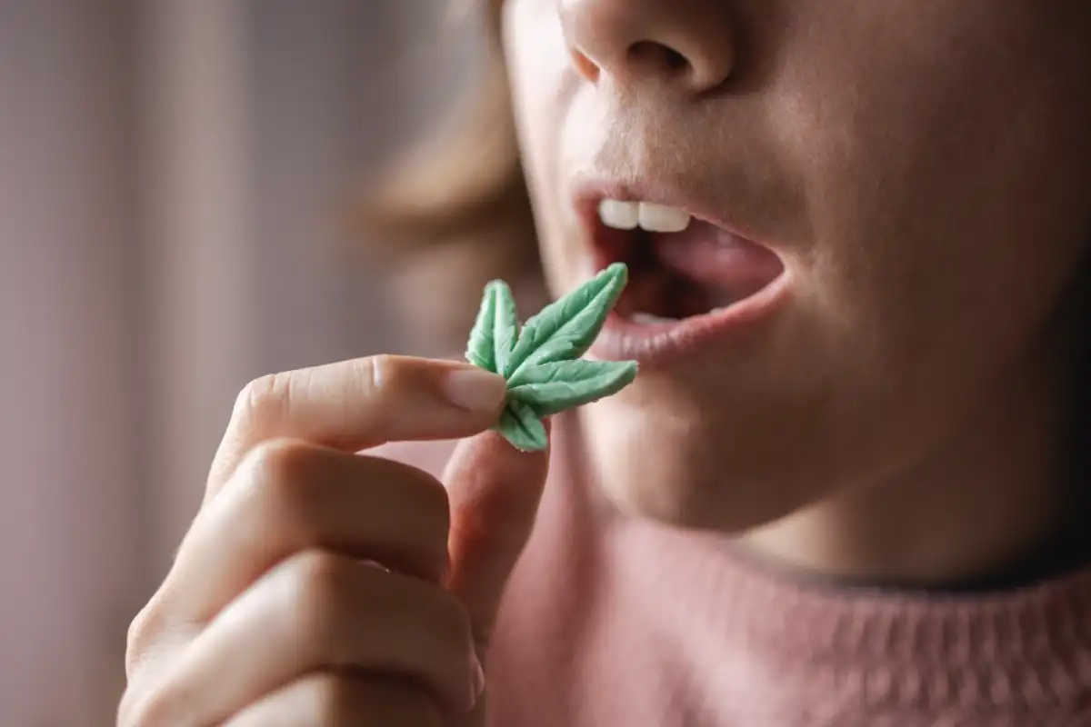 Woman eating edible cannabis leaf for anxiety treatment